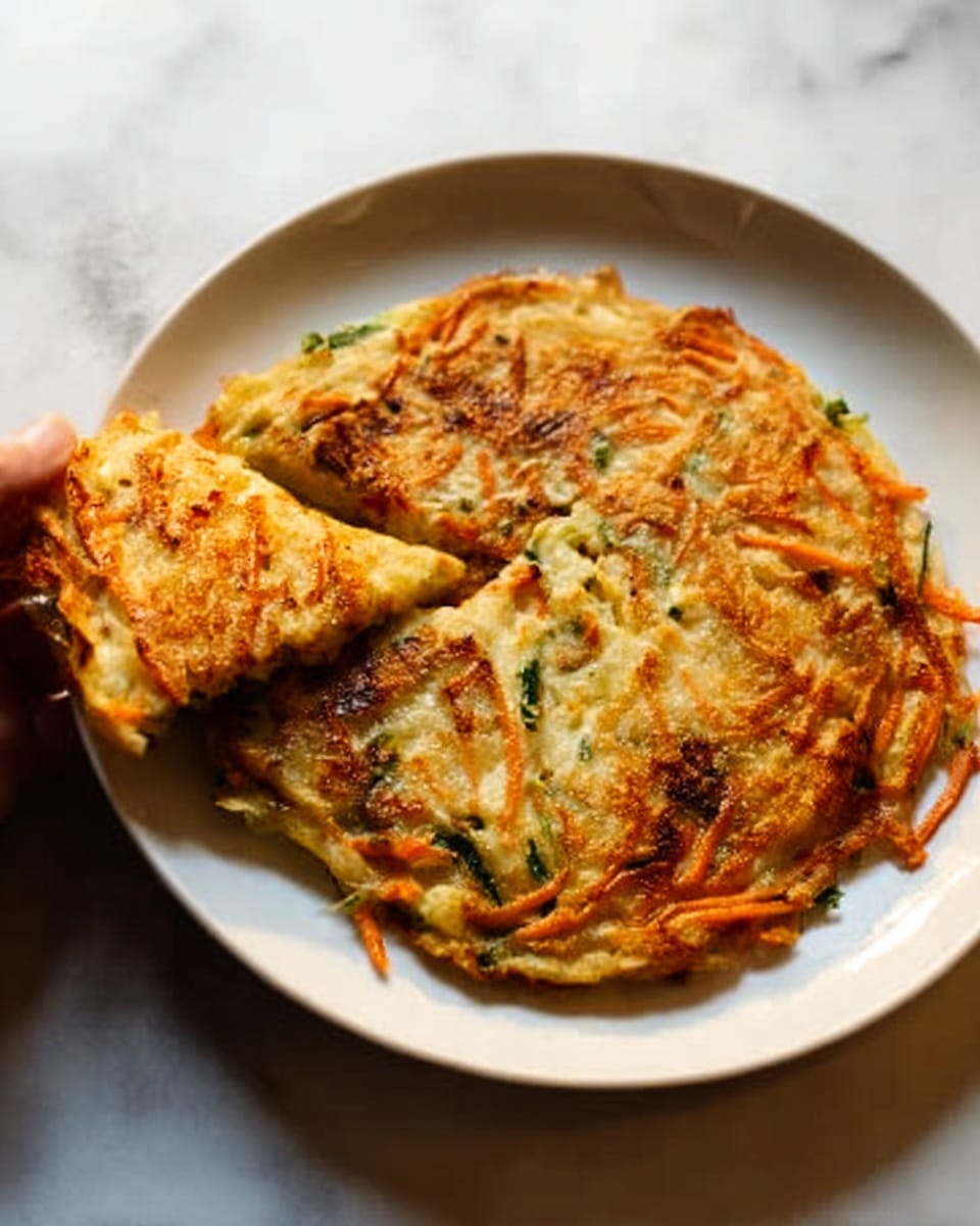 The image shows a stack of six crispy golden-brown vegetable fritters placed on a white plate. Each fritter is thick and textured, with visible bits of green herbs, orange carrot shreds, and light yellow cabbage layers. The edges are browned and crispy, while the inside looks soft and moist, creating a contrast in texture. The stack is slightly uneven, giving a homemade feel. The background is a white marbled texture with warm lighting that highlights the fritters' colors and crispy surface. photo taken with an iphone --ar 4:5 --v 7