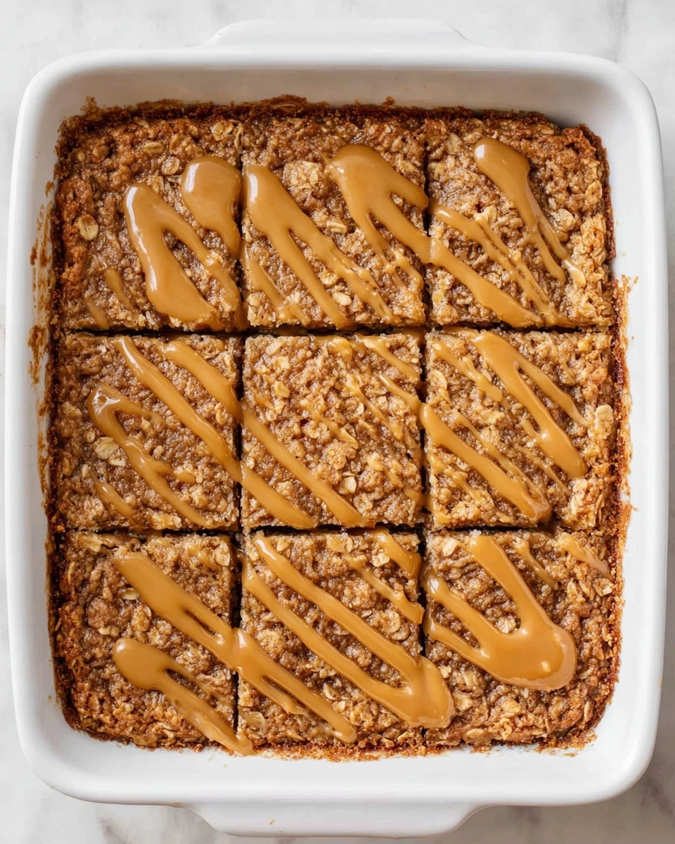 A square piece of oatmeal baked good sits on a white plate with a thin dark rim, placed on a white marbled surface. The oatmeal layer is dense and crumbly with a light brown color. On top, there are two thick banana slices arranged side by side near the center. A caramel-colored sauce is drizzled over the oatmeal and banana slices in uneven stripes, with some sauce dripping down onto the plate. A silver fork rests on the right edge of the plate, pointing toward the food. Part of the rest of the oatmeal dish is visible to the left, still in a white baking dish, showing the same texture and drizzled sauce. Photo taken with an iphone --ar 4:5 --v 7