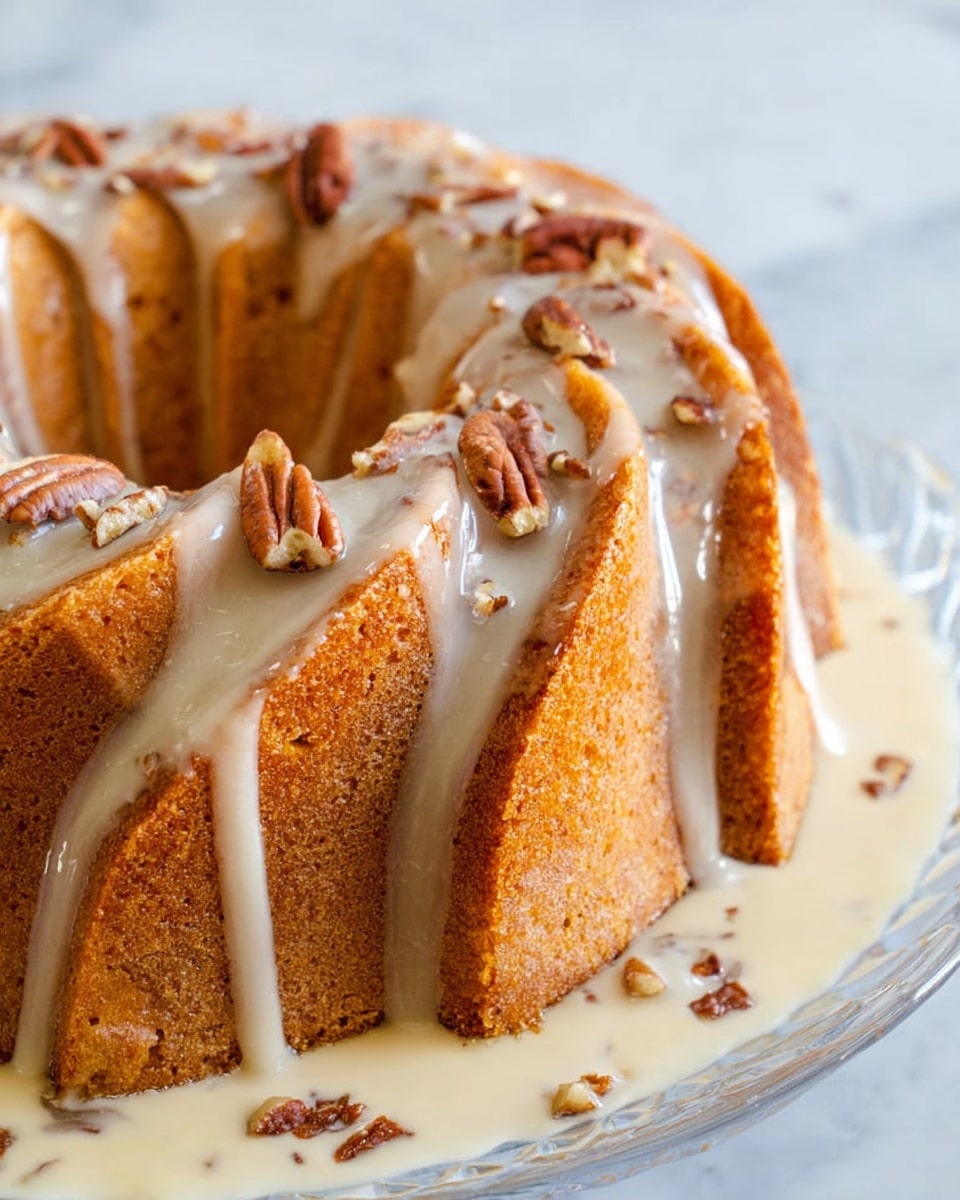 The image shows a bundt cake with a light brown, moist texture and a swirled pattern on top, sitting on a clear glass plate. The cake is partially covered in a thin, creamy glaze that drips down the ridges, with scattered pecan pieces both on the glaze and around the plate. The cake rests in a shallow pool of pale cream sauce, thick and smooth, also containing pecan pieces. The background surface is white marble. Photo taken with an iphone --ar 4:5 --v 7