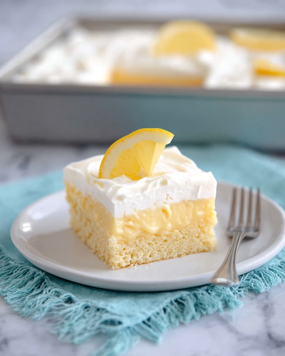 A square piece of lemon cake sits on a simple white plate. The cake has two distinct layers: a bottom layer of soft, light yellow cake with small holes and a thick, creamy lemon filling that slightly drips down in three places on the front side. The top layer is a smooth, thick white frosting, with a small thin slice of lemon placed neatly on top. In the background, there is one whole lemon and one lemon cut in half, all set on a white marbled texture. The plate sits on a light blue cloth. Photo taken with an iphone --ar 4:5 --v 7