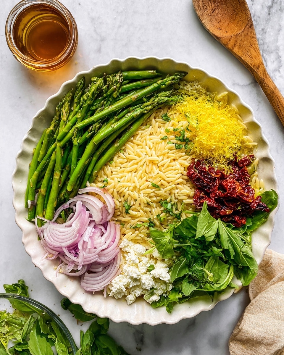 The dish is served in a white, fluted bowl placed on a white marbled surface. It has five distinct layers arranged in sections on top of a base of pale yellow orzo pasta. On the left is a large portion of bright green, sliced asparagus with a fresh and crunchy texture. To the right of the asparagus is a small pile of finely grated bright yellow lemon zest. Next to it, there is a mound of white crumbly cheese, likely feta or ricotta. Below the cheese, there’s a pile of thinly sliced light purple-red onions. Beneath the onions, there is a section of deep red, sun-dried tomatoes with a slightly wrinkled texture. In the center, fresh green leafy herbs are placed on top of all the ingredients. A small glass container with a brownish liquid sits nearby and a wooden spoon lies beside the bowl. photo taken with an iphone --ar 4:5 --v 7